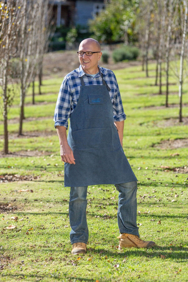 Brian wearing an Aussie Gardener canvas apron standing in an orchard.